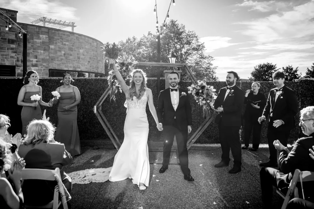 the bride and groom celebrate as they walk back down the aisle after getting married. Shot at Carmen's event centre, Hamilton by Pixelesque Photography.