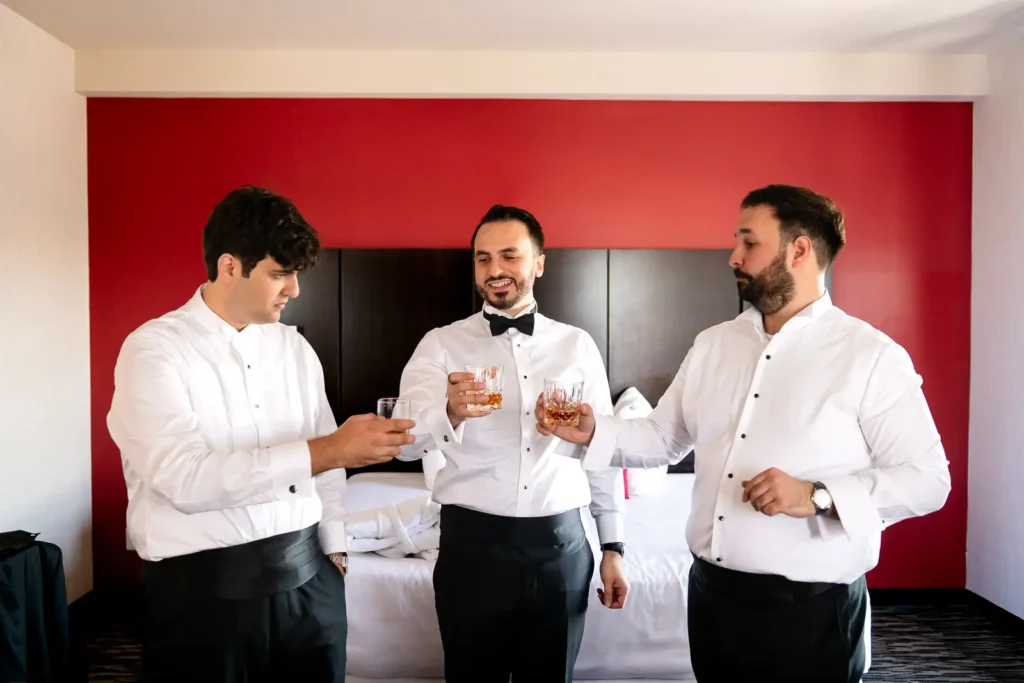 the groom and his two groomsmen toast their drinks. Shot in C hotel, Hamilton by Pixelesque Photography.