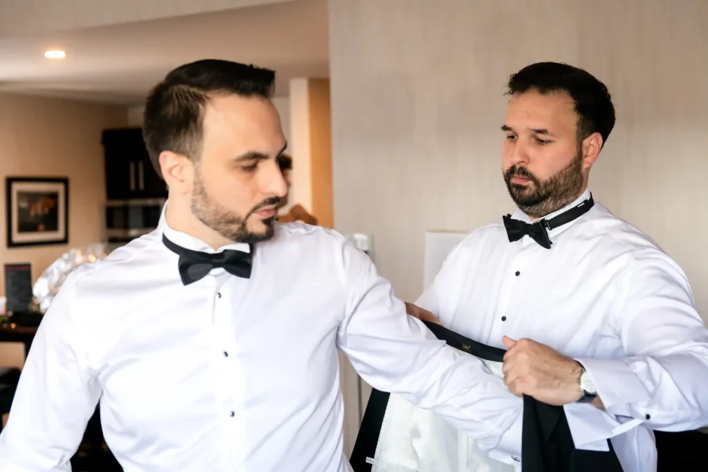 the best man puts the groom's jacket on him. Shot in C hotel, Hamilton by Pixelesque Photography.