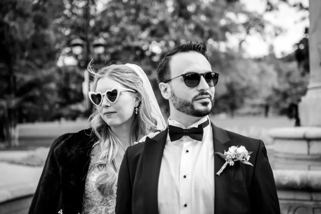 a wedding couple strike a serious pose with the bride wearing a fur coat. Shot at Hamilton's Gage Park by Pixelesque Photography.