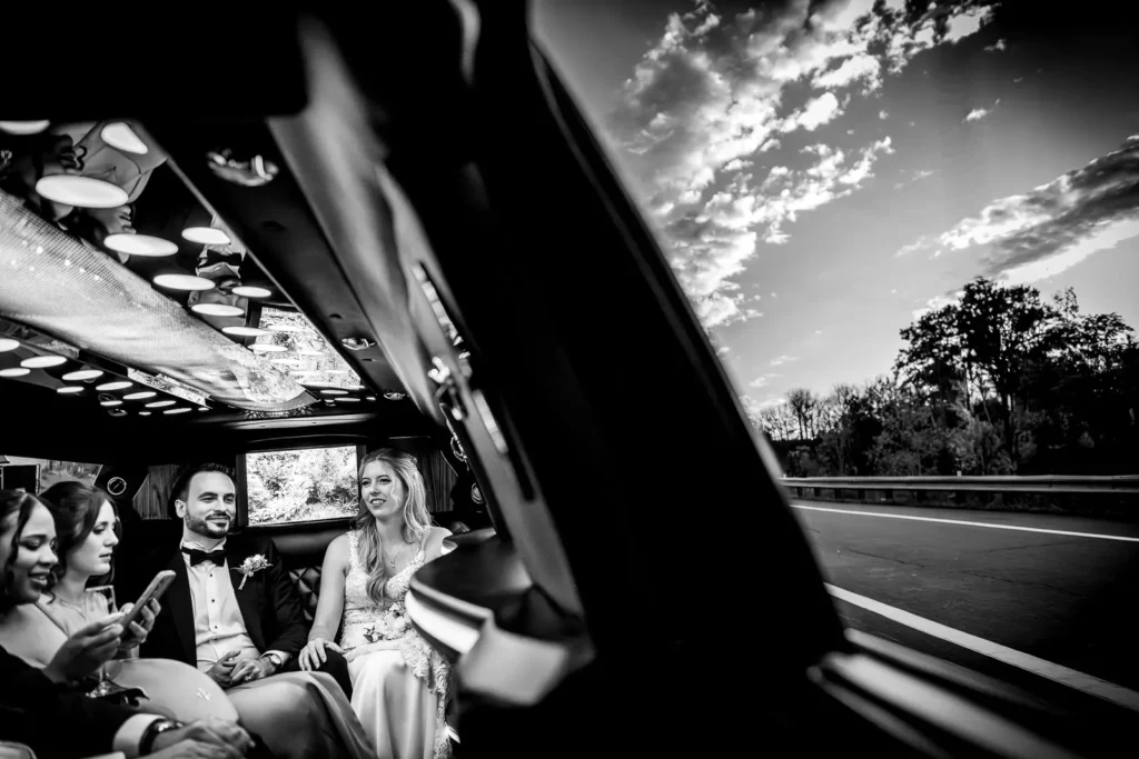 the wedding couple hang out in the back of a limo and half the image is of the window and cloudy sky outside. Shot at Hamilton's Gage Park by Pixelesque Photography.