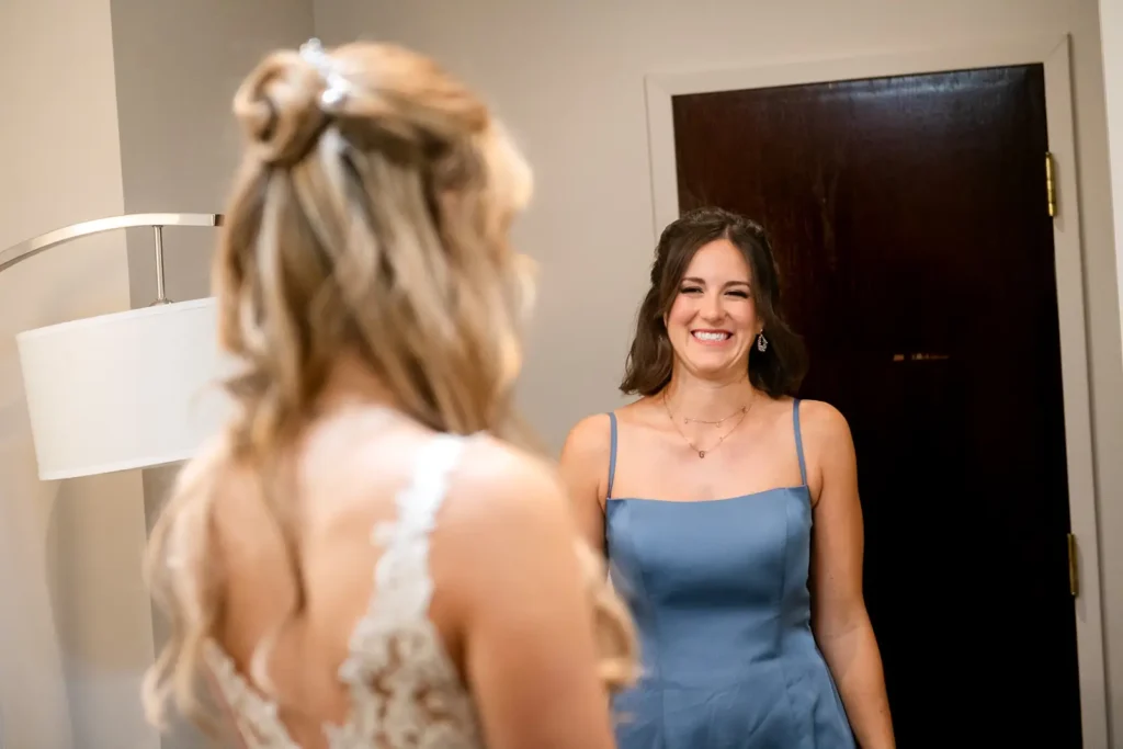 a bridesmaid laughs with the bride in the bridal suite. Shot at Carmen's event centre, Hamilton by Pixelesque Photography.