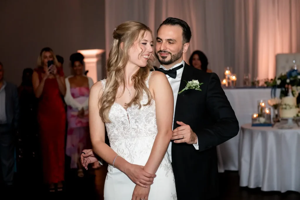 the groom holds his bride as they share their first dance. Shot at Carmen's Event Centre, Hamilton by Pixelesque Photography.