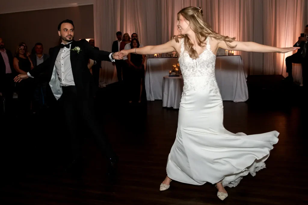 the groom twirls his bride as they have their first dance. Shot at Carmen's Event Centre, Hamilton by Pixelesque Photography.