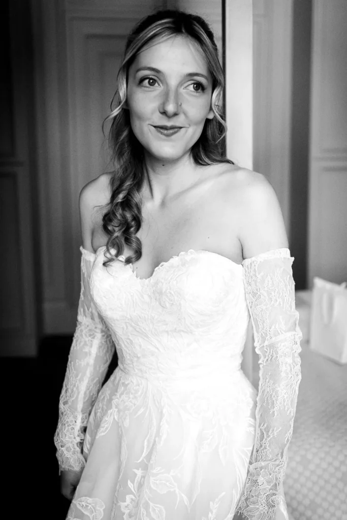 Bride looking towards a window fully dressed.
