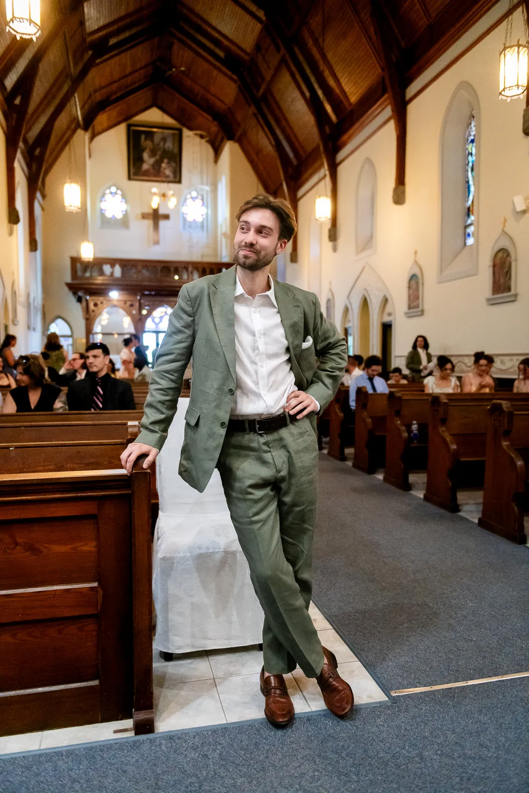 Groom strikes a pose against a pew in St Gregory's church in Picton.