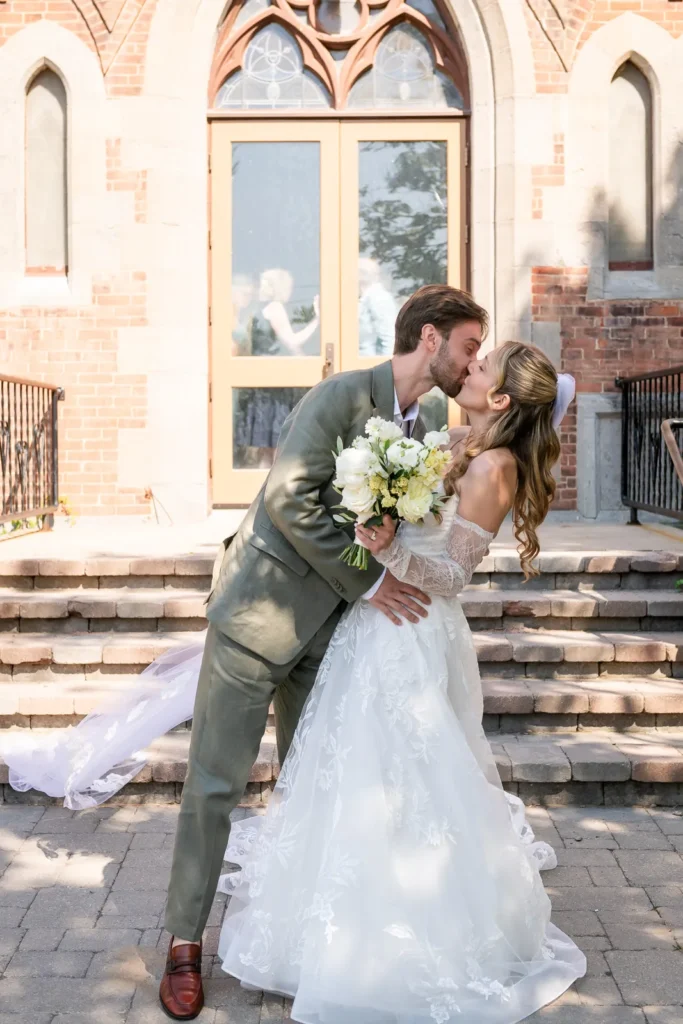 Bride and groom share a kiss outside St. Gregory’s Church.