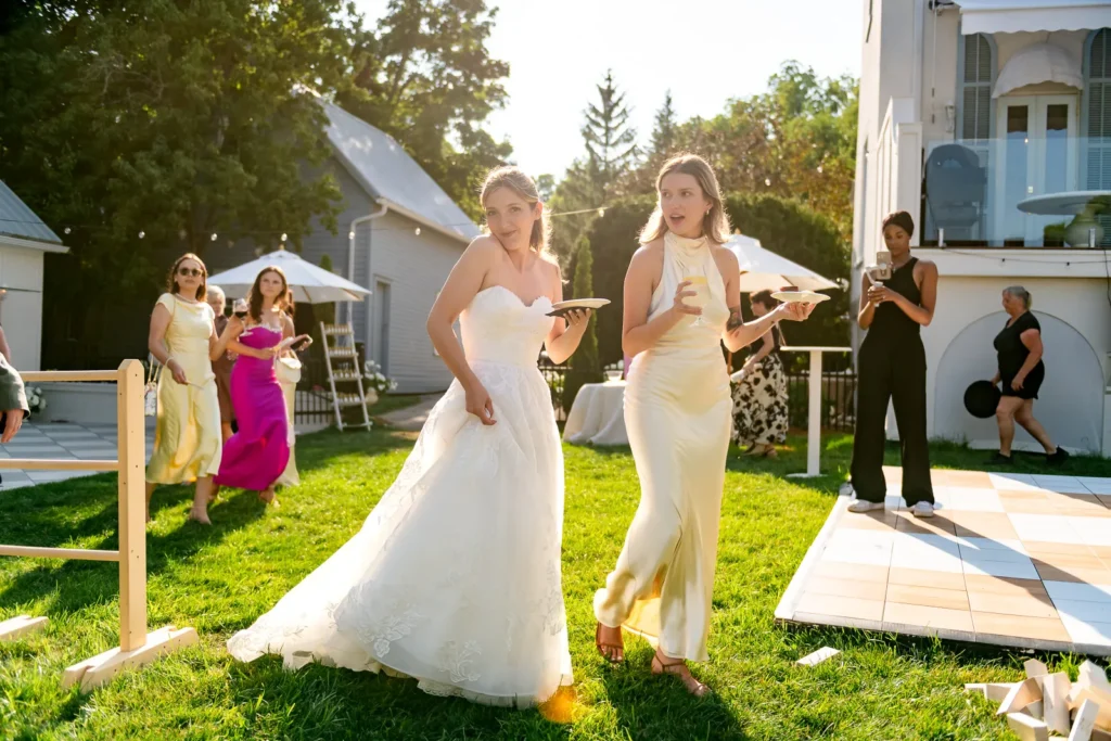 Guests enjoying cocktail hour with white parasols in a waterfront backyard.