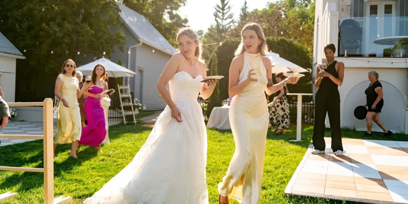 Guests enjoying cocktail hour with white parasols in a waterfront backyard.