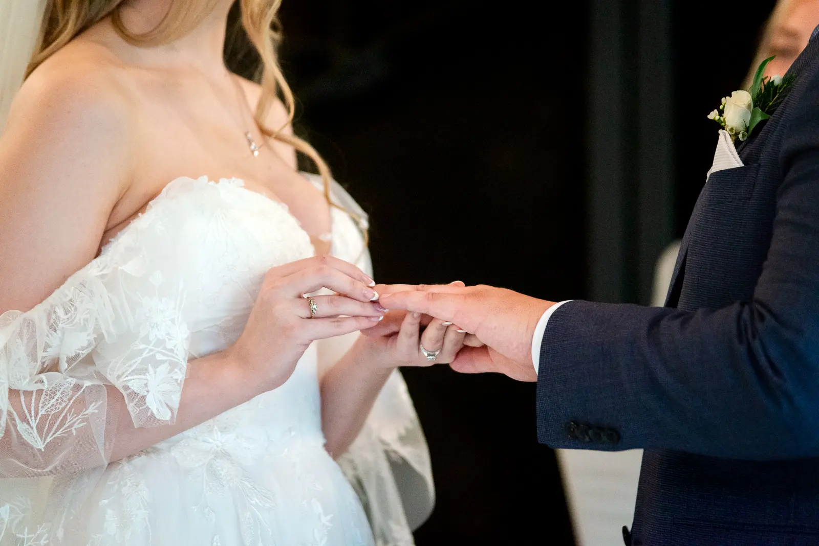 a bride puts a ring on her groom's hand at Ancaster Mill in Hamilton, Ontario.