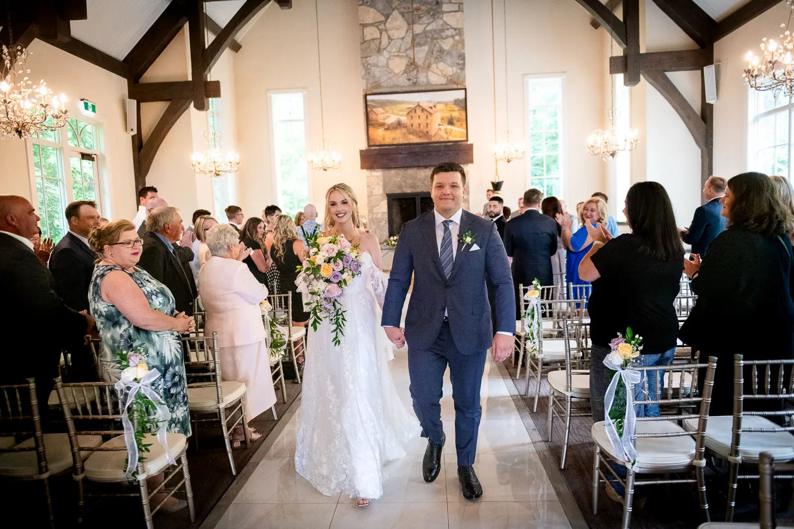 the newlywed bride and groom walk back down the aisle at Ancaster Mill in Hamilton, Ontario.