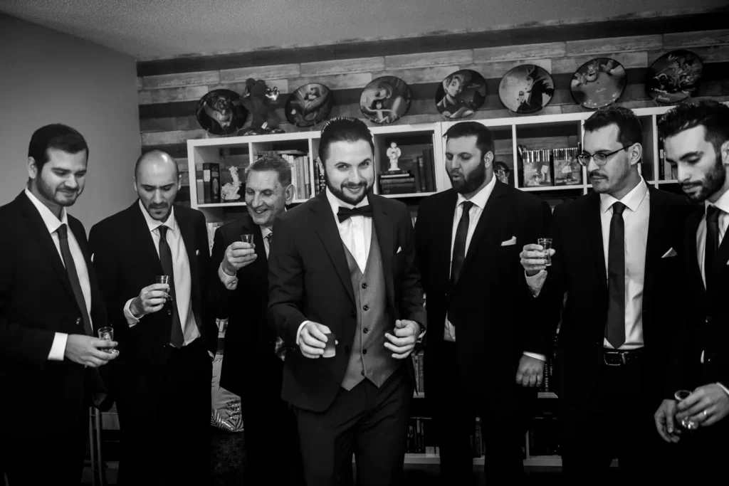 A groom and his groomsmen have a drink at his house as the wedding day starts