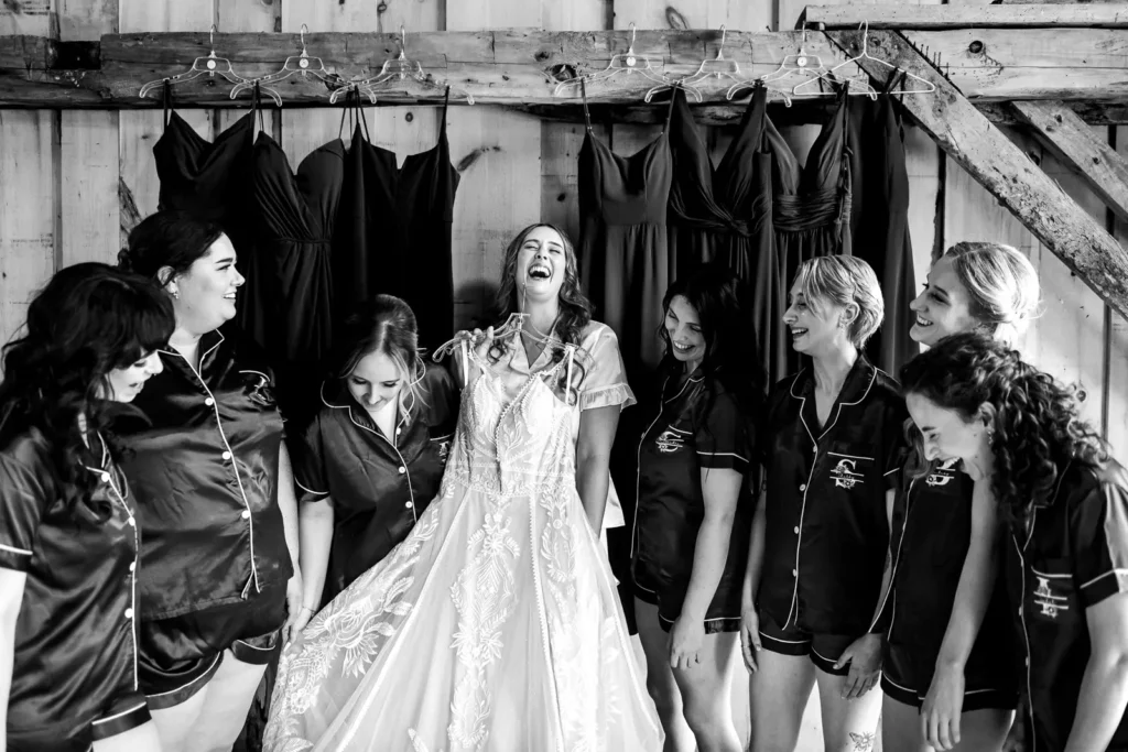 a bride holds her wedding dress and laughs as her bridesmaids look on at Homegrown Hideaway in Norfolk County, Ontario.