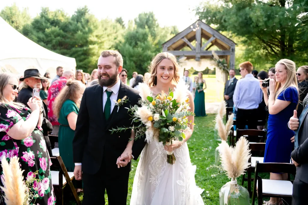 a newlywed bride and groom walk back down the aisle overcome with emotion at Homegrown Hideaway in Norfolk County, Ontario.