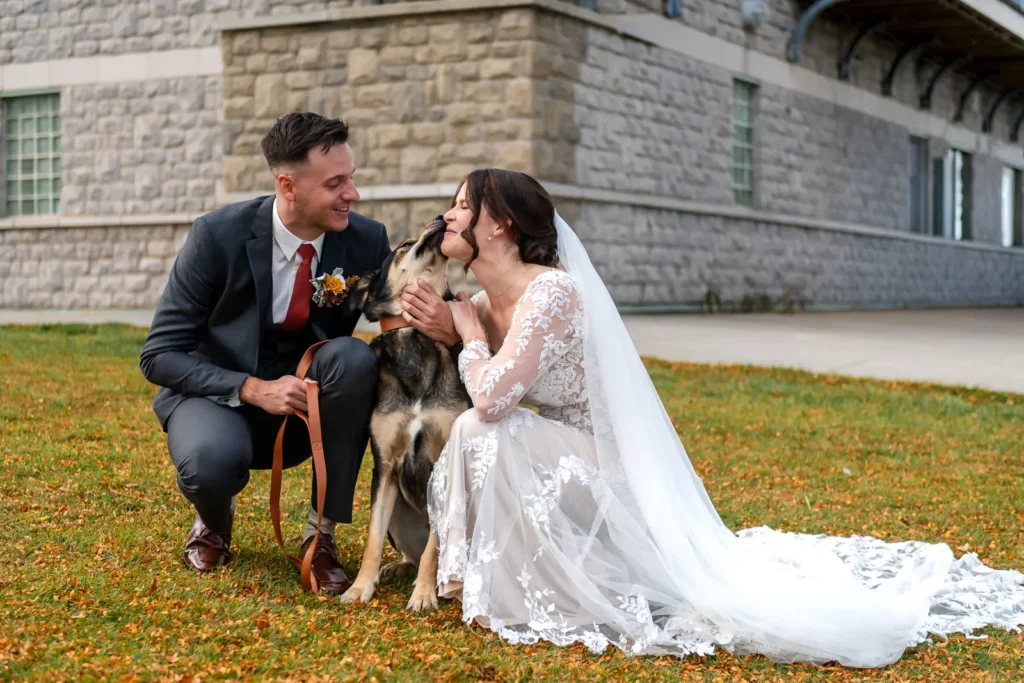 the wedding couple play with their dog at The Lakeview by Carmen's in Hamilton.