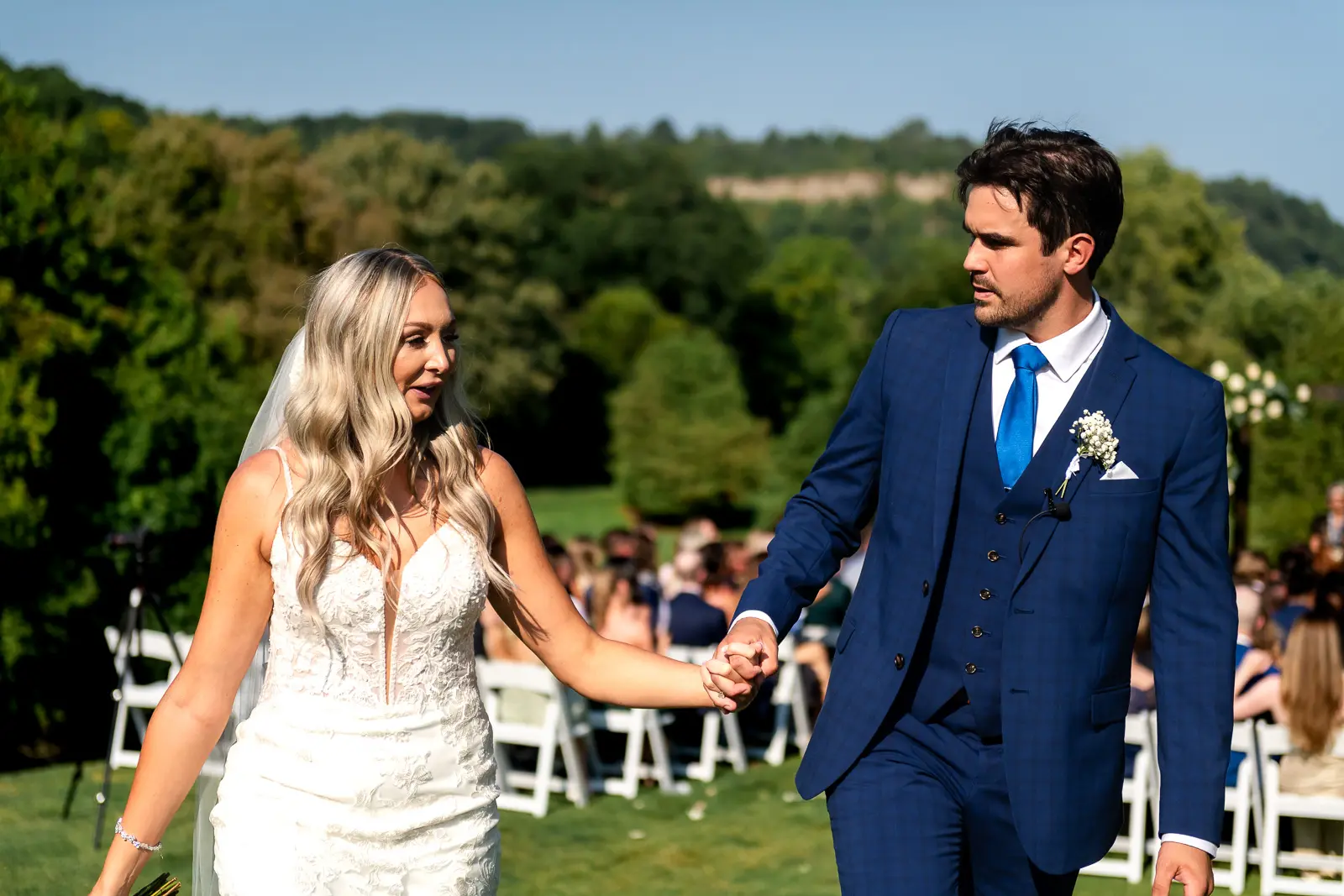 the newly married couple walk away from the ceremony site at dundas valley golf and curling club