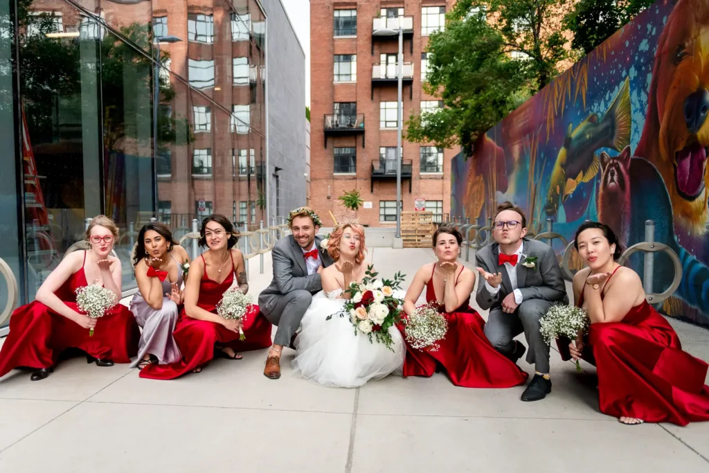 the bride, groom, and bridal party do a slavic squat pose during bridal portraits in downtown toronto