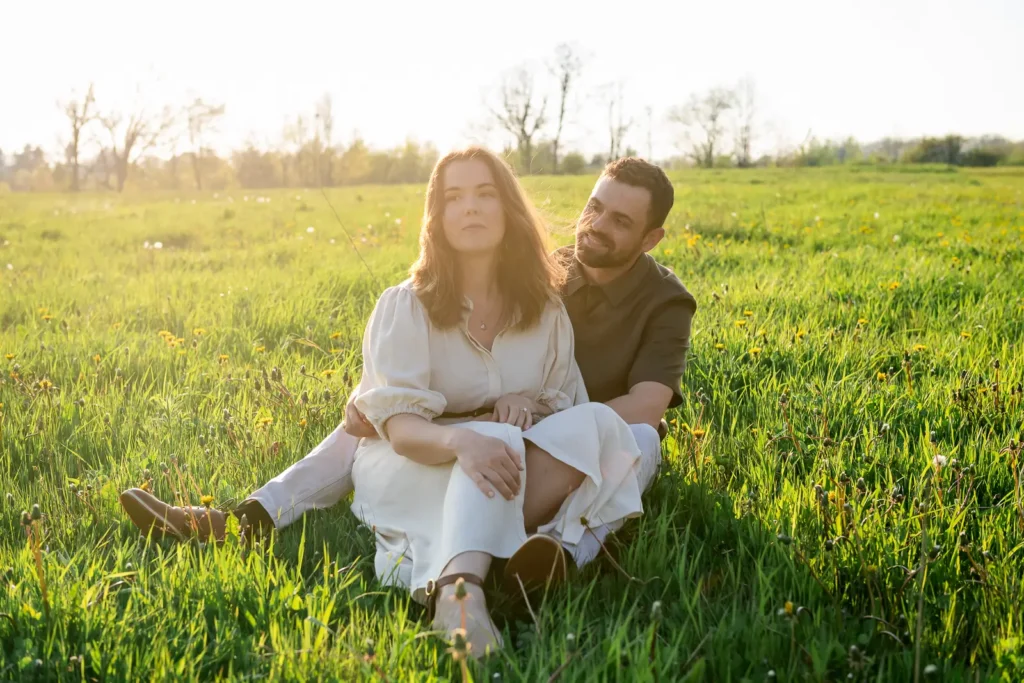 Couple sitting in open fields at City View Park during Burlington engagement session
