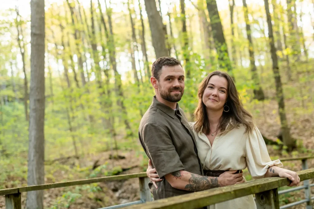 Kate and Kyle pose by a bridge in the wooded trails during their Kerncliff Park engagement session in Burlington Ontario